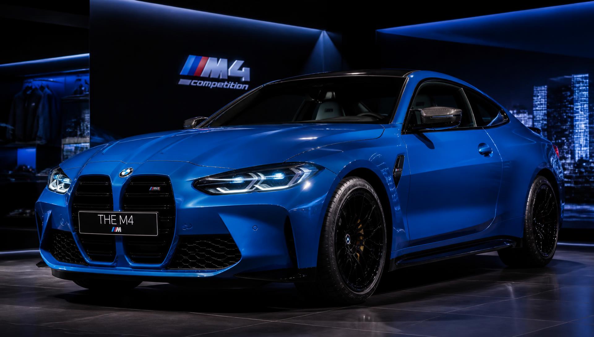 Blue BMW M4 Competition in a modern showroom